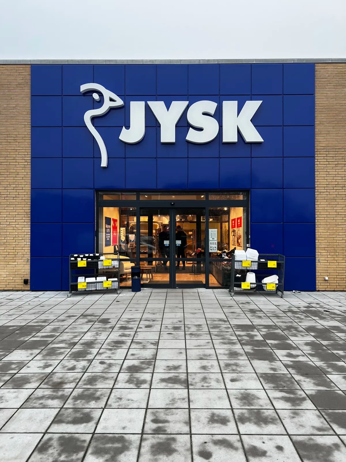 Facadebogstaver monteret på blå facadeplader ved indgangen til JYSK