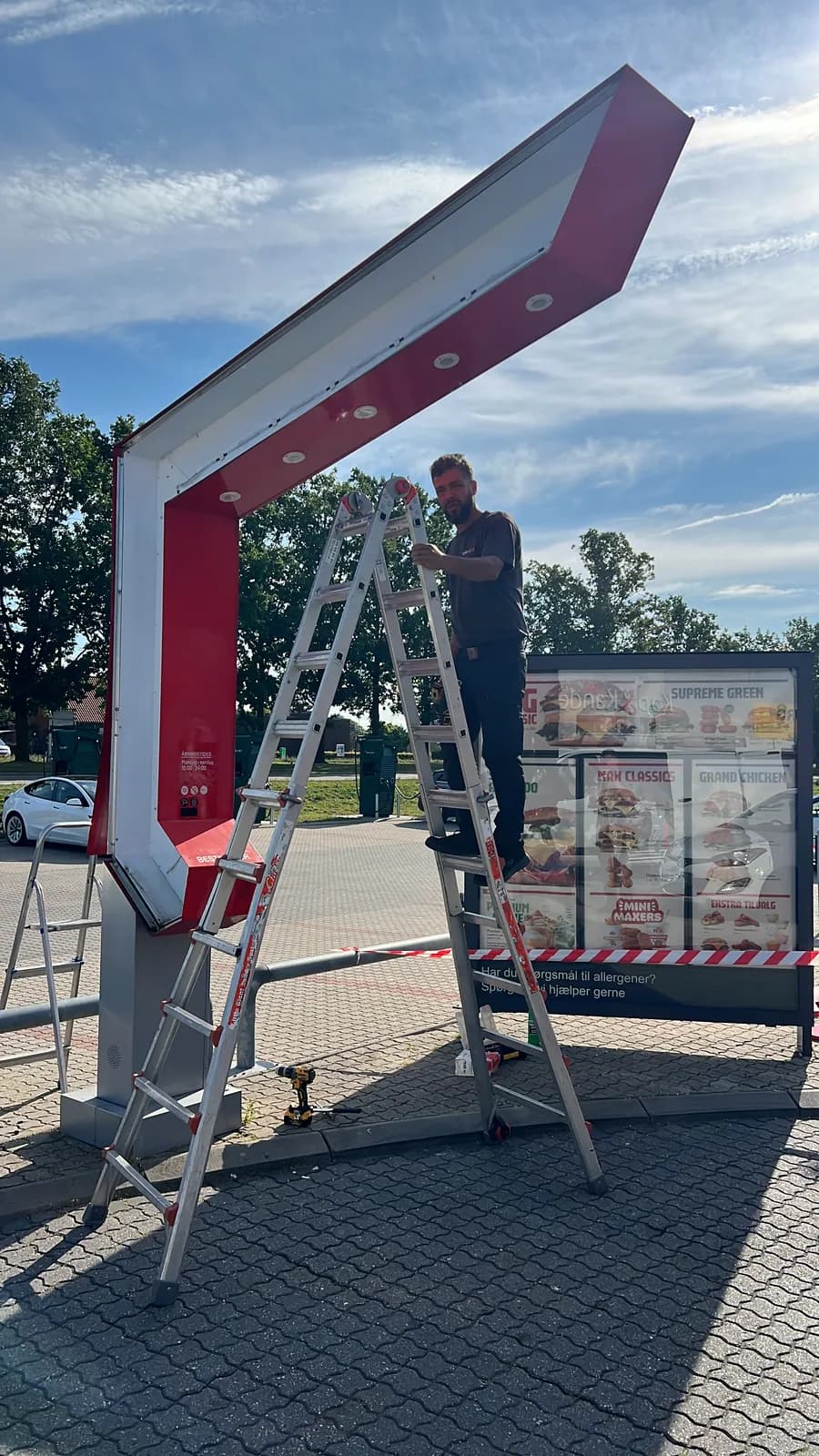 Montør fra TopSkilte monterer menutavle og bestillingsstander ved MAX drive-in
