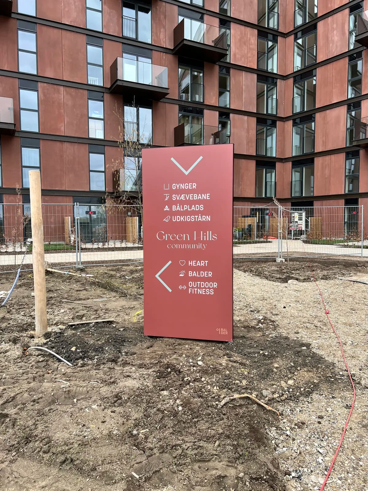 Wayfinding-pylon i bordeaux med piktogrammer til Green Hills Community for Balder