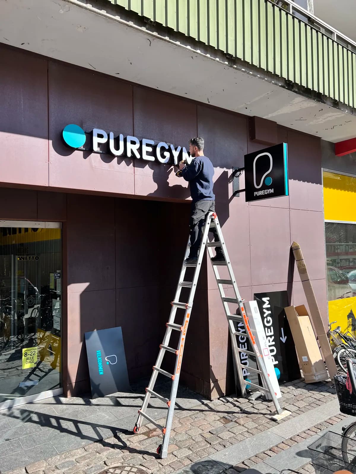 Montage af facadebogstaver til PureGym over indgangen, set fra lift