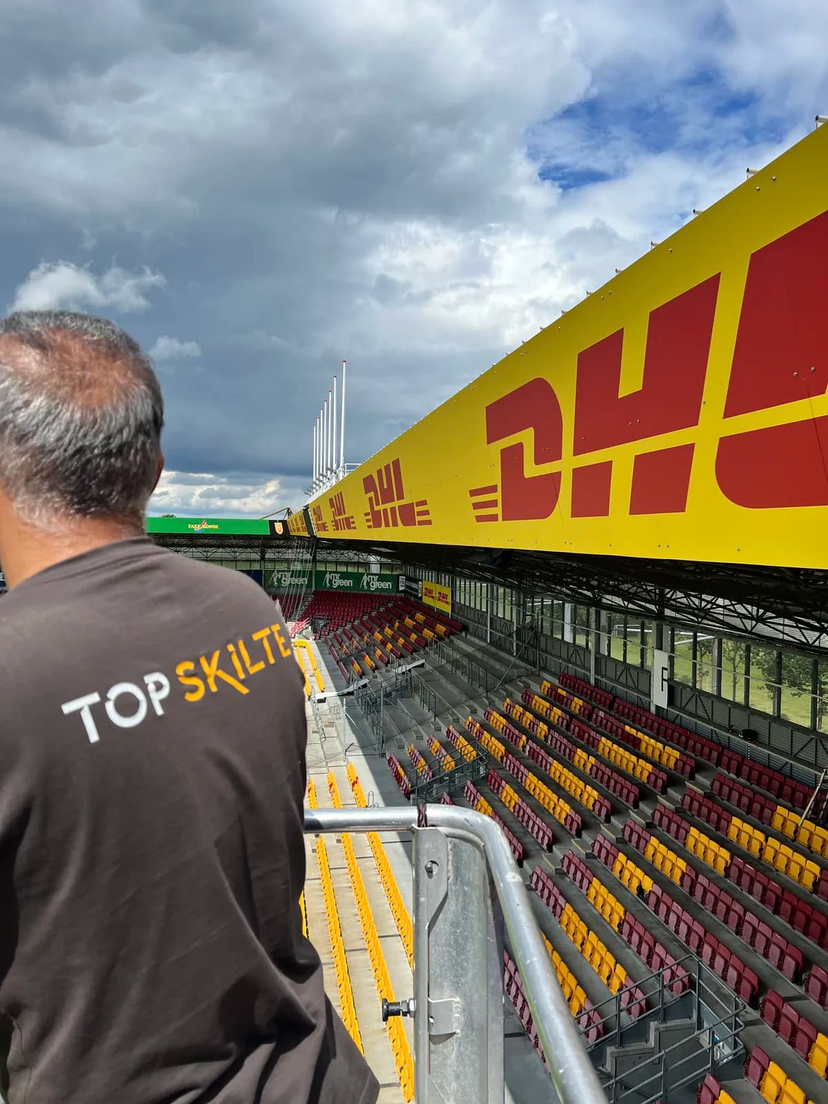 Montage af DHL-bannere på tribunekanten på Right to Dream Park set fra montørens perspektiv